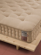 Nahaufnahme einer beigen Matratze mit einem Etikett, das 100% Bio-Baumwolle anzeigt.